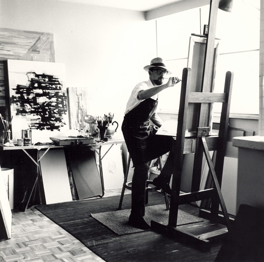 Artist in studio painting at an easel