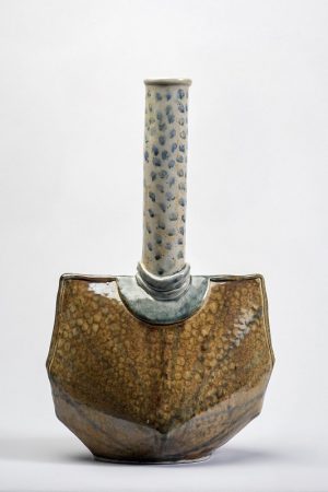 A glazed vase with brown base and long blue and white neck