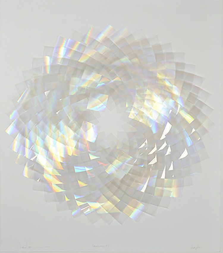 Photo of shiny, iridescent layers of plastic in a circular shape on white background.